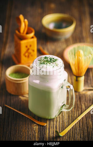 Delicious Grüntee Frappe in Glasschale auf Holztisch Stockfoto