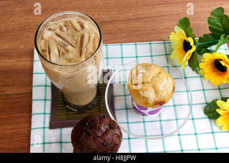 Kakao Schokolade Smoothie in Glas und Muffin auf Holztisch Stockfoto