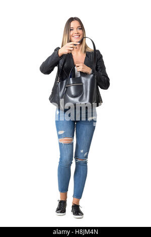 Fröhlich lächelnd lässige Frau Jeans und Jacke Handtasche halten. Ganzkörper-Länge-Porträt isoliert auf weißem Hintergrund Stockfoto