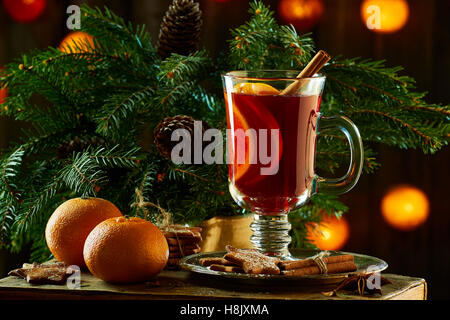 Glühwein mit Zimtstangen, Mandarine, Ingwer Cookies und Fichte Zweige Stockfoto