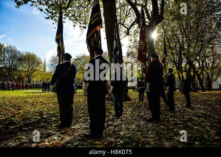 Royal British Legion Fahnenträger stehen, um Aufmerksamkeit auf der Parade während einer Erinnerung Sonntagsgottesdienst in Queen Square, Bristol, statt zu Ehren für Mitglieder der Streitkräfte, die in größeren Konflikten gestorben sind. Stockfoto