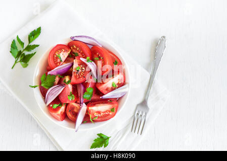 Tomatensalat mit Zwiebeln, Petersilie und Pfeffer in Schüssel - gesunde vegetarische vegane Lebensmittel Vorspeise Stockfoto