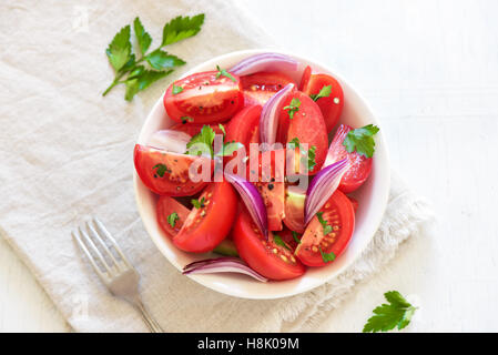 Tomatensalat mit Zwiebeln, Petersilie und Pfeffer in Schüssel - gesunde vegetarische vegane Lebensmittel Vorspeise Stockfoto