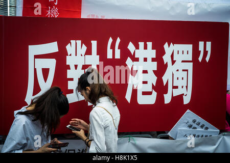 Hong Kong, Hong Kong. 13. November 2016. Chinesische Schriftzeichen: Anti-Hong Kong Unabhängigkeit. Anti-Hong Kong Unabhängigkeit und Unterstützung für die Auslegung der nationalen Volksarmee Kongress Rallye, außerhalb der Legislative Council und Tamar Park Kundgebung eine, die NPC ständigen Ausschusses über die Auslegung von Artikel 104 des Grundgesetzes zu unterstützen. Der Veranstalter eine Plattform und einem großen Bildschirm in der Legislative Council Road eingerichtet. Liga: Schätzungen die Rallye von etwa 40.000 Menschen beteiligt, eine große Anzahl von handgeführten Parolen und die Flagge der Teilnehmer. © Yeung Kwan/Pacific Press/Alamy Live-Nachrichten Stockfoto