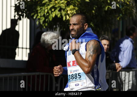 Athen, Griechenland. 13. November 2016. Ein Läufer trägt eine griechische Flagge. Tausende von Menschen aus der ganzen Welt nahmen an 2016 Athen Marathon authentisch, die in der Stadt von Marathon beginnt und endet in Athen, die Route, die der Legende nach zuerst von den griechischen Boten Pheidippides 490 v. Chr. betrieben wurde. © Michael Debets/Pacific Press/Alamy Live-Nachrichten Stockfoto