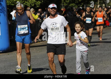 Athen, Griechenland. 13. November 2016. Ein Läufer läuft mit seiner Tochter in Athen Marathon. Tausende von Menschen aus der ganzen Welt nahmen an 2016 Athen Marathon authentisch, die in der Stadt von Marathon beginnt und endet in Athen, die Route, die der Legende nach zuerst von den griechischen Boten Pheidippides 490 v. Chr. betrieben wurde. © Michael Debets/Pacific Press/Alamy Live-Nachrichten Stockfoto