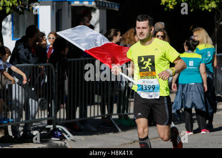 Athen, Griechenland. 13. November 2016. Ein Läufer trägt eine polnische Flagge. Tausende von Menschen aus der ganzen Welt nahmen an 2016 Athen Marathon authentisch, die in der Stadt von Marathon beginnt und endet in Athen, die Route, die der Legende nach zuerst von den griechischen Boten Pheidippides 490 v. Chr. betrieben wurde. © Michael Debets/Pacific Press/Alamy Live-Nachrichten Stockfoto