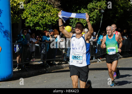 Athen, Griechenland. 13. November 2016. Ein Läufer trägt eine griechische Flagge. Tausende von Menschen aus der ganzen Welt nahmen an 2016 Athen Marathon authentisch, die in der Stadt von Marathon beginnt und endet in Athen, die Route, die der Legende nach zuerst von den griechischen Boten Pheidippides 490 v. Chr. betrieben wurde. © Michael Debets/Pacific Press/Alamy Live-Nachrichten Stockfoto