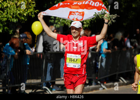 Athen, Griechenland. 13. November 2016. Ein Läufer trägt eine polnische Flagge. Tausende von Menschen aus der ganzen Welt nahmen an 2016 Athen Marathon authentisch, die in der Stadt von Marathon beginnt und endet in Athen, die Route, die der Legende nach zuerst von den griechischen Boten Pheidippides 490 v. Chr. betrieben wurde. © Michael Debets/Pacific Press/Alamy Live-Nachrichten Stockfoto