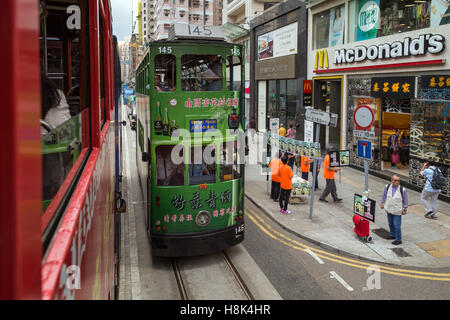 Blick auf eine grüne Straßenbahn und Straße vom Oberdeck einer doppelstöckigen Straßenbahn auf der Johnston Road in Causeway Bay in Hongkong. Stockfoto