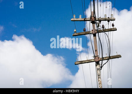 Alte elektrische Holzpfahl und blauer Himmelshintergrund Stockfoto
