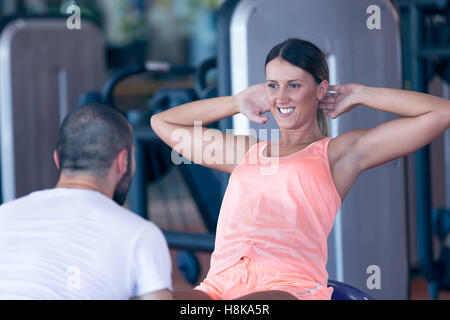 Persönlicher Trainer arbeiten mit seinem Mandanten im Fitness-Studio Stockfoto