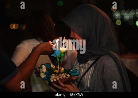 Bangkok, Thailand. 14. November 2016. Ein paar Leuchten Krathong bevor es über Wasser entlang des Chao Phraya River in Bangkok, der Hauptstadt von Thailand, auf 14. November 2016. Thailand beobachtet das jährliche Loy Krathong Festival am Montag. Als eine Tradition, die mindestens sieben Jahrhunderte gefolgt wurde, setzen Menschen flott Lotus-förmigen Flöße, geschmückt mit Kerzen, Räucherstäbchen und Blumen, bekannt als Krathongs, um die zwölfte Nacht der Vollmond des thailändischen Kalenders und wollen ein Jahr Pech, vom Wasser weggespült werden. © Li Mangmang/Xinhua/Alamy Live-Nachrichten Stockfoto