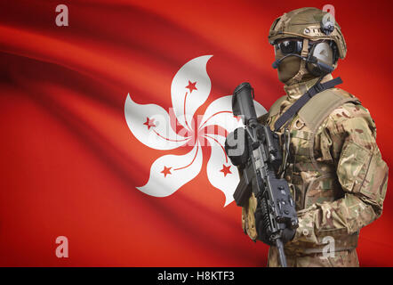 Soldat im Helm holding Maschinengewehr mit Nationalflagge auf Hintergrund - Hong Kong Stockfoto