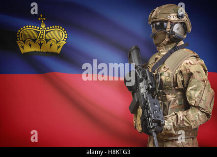 Soldat im Helm holding Maschinengewehr mit Nationalflagge auf Hintergrund - Liechtenstein Stockfoto