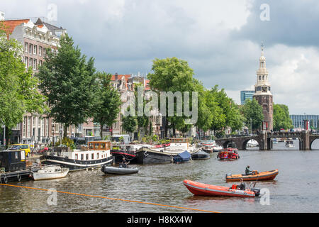 Amsterdam, Niederlande am Wasser Blick auf Boote segeln durch eine Amsterdam-Kanal.  Im Hintergrund ist der berühmte Montalbaan Stockfoto