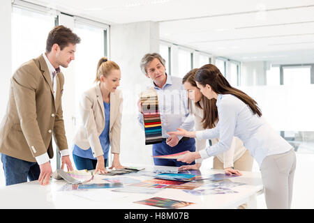 Team von Design-Profis mit Farbfelder mit Diskussion am Tisch im neuen Büro Stockfoto