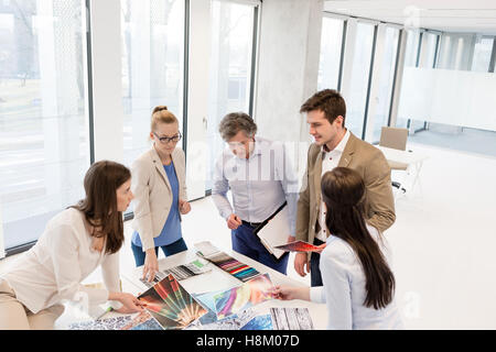 Erhöhte Ansicht von Design-Profis mit Diskussion am Tisch im neuen Büro Stockfoto