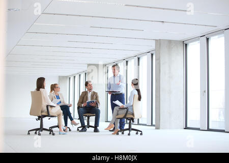 Reife Geschäftsmann diskutieren mit Kollegen sitzen auf Stuhl im neuen Büro Stockfoto