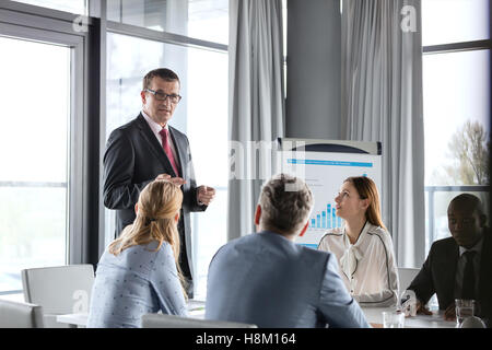 Reife Geschäftsmann mit Diskussion mit Kollegen im Sitzungsraum Stockfoto