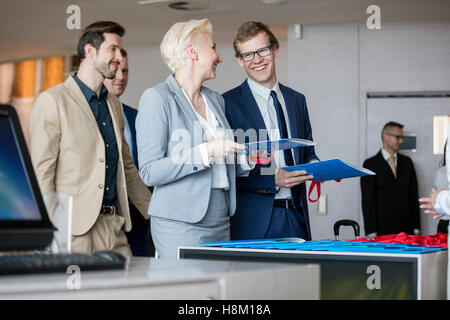 Glücklich Geschäftsleute sprechen halten Sie Dateien am Empfangstresen im Convention center Stockfoto