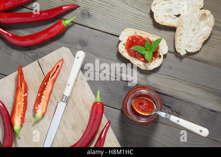 Aufwand für die roten Chilischoten Marmelade auf Brot Stockfoto