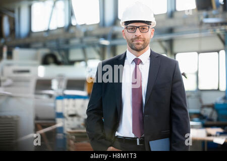 Porträt von zuversichtlich Mitte adult Geschäftsmann tragen Helm in der Metallindustrie Stockfoto