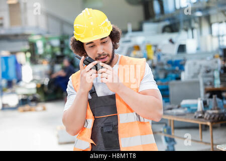 Junge Arbeiter tragen von Schutzkleidung mit Walkie-talkie in der Metallbranche Stockfoto