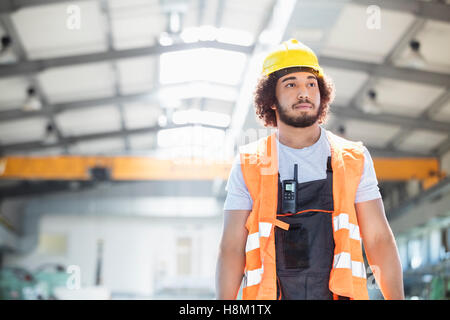 Junge Arbeiter tragen Schutzkleidung wegsehen in der Metallbranche Stockfoto