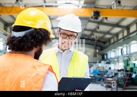 Männlichen Vorgesetzten diskutieren mit Arbeiter in der Metallindustrie Stockfoto