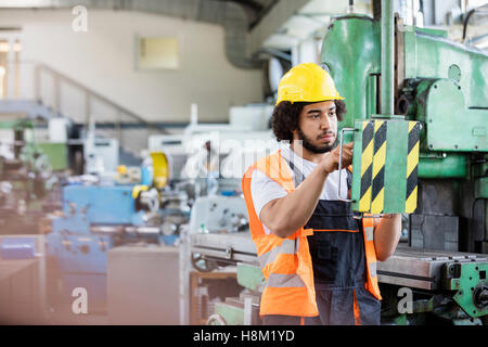 Junge Arbeiter, die Bedienung von Maschinen in der Metallbranche Stockfoto