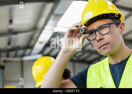 Mitte Erwachsenen Arbeiter Prüfung Metall in der Industrie Stockfoto
