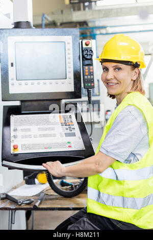 Porträt der Arbeitnehmerin, die Bedienung von Maschinen am Bedienfeld in Fabrik Stockfoto