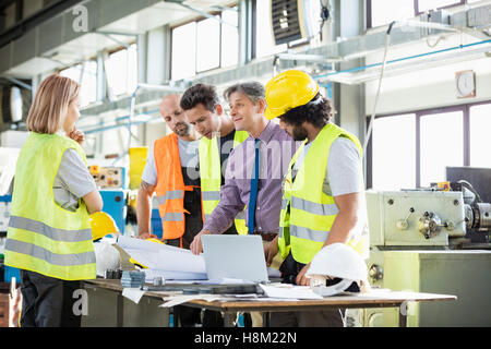 Supervisor und Arbeiter diskutieren über Baupläne in der Industrie Stockfoto