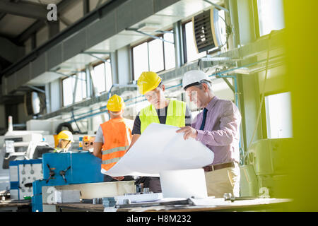 Architekten und Arbeiter lesen Blaupause am Tisch in der Industrie Stockfoto