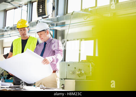 Männliche Architekten und Arbeiter Prüfung Blaupause in der Metallbranche Stockfoto