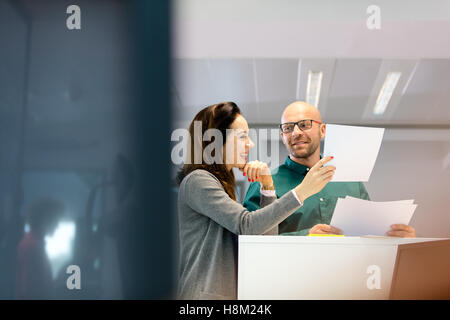 Unternehmer und Unternehmerin diskutieren über Dokumente in office Stockfoto