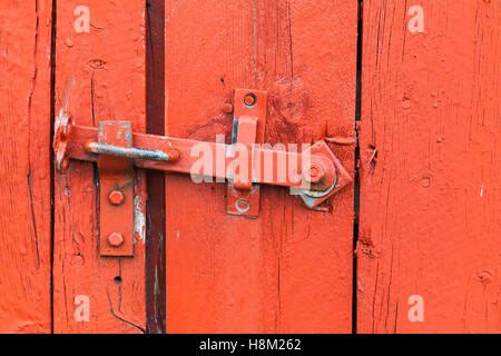 Alte Metall Riegel auf rote Holztür, Nahaufnahme Stockfoto