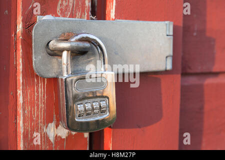 Alte Vintage rote Holztür hängen Zahlenschloss Stockfoto