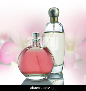 Parfüm-Flaschen mit rosa Blumen auf weißem Hintergrund Stockfoto