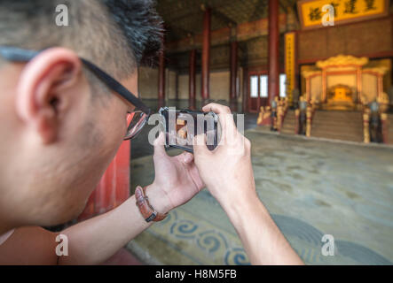 Peking China - Touristen fotografieren auf ihren Handys am Eingang des Palastmuseums in der verbotenen Stadt gelegen Stockfoto