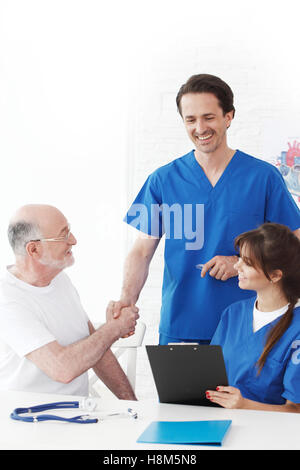 Glücklich senior Patienten und Ärzte im Krankenhaus, die Hände schütteln Stockfoto