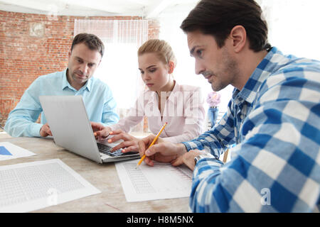 Gruppe von Menschen, die Arbeit mit Dokumenten und laptop Stockfoto