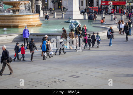 Ein "Krokodil" von Schulkindern folgen ihrem Lehrer über Trafalgar Square. Stockfoto