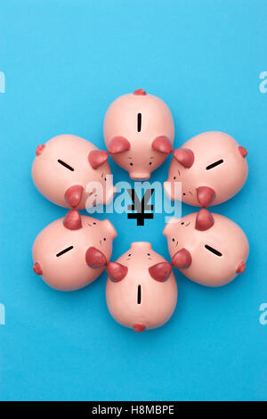 Sparschweine, die rund um einen Yen Yuan symbol Ansicht von oben Stockfoto