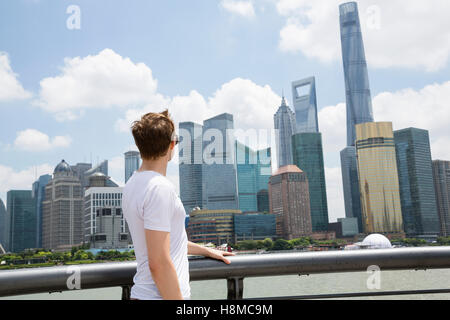 Seitenansicht des Menschen gegen bewölktem Himmel mit Blick auf Shanghai World Financial Center Stockfoto