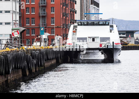 Passagier-Katamaran an der Pier mit alten Reifen Stockfoto