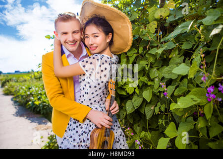 Porträt des glücklichen Paares umarmen von Pflanzen Stockfoto