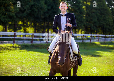 Porträt von glücklicher Mann Reiten auf Feld Stockfoto