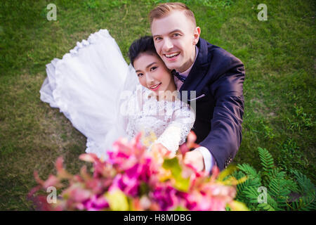 Hohen Winkel Bildniss glückliches Hochzeitspaar auf Wiese Stockfoto